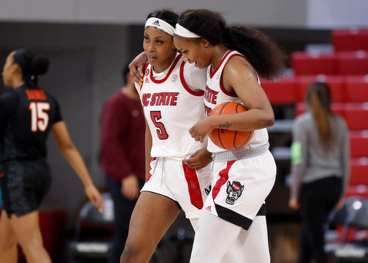 N.C. State’s Kayla Jones (25), right and Jada Boyd (5) walk off the court after N.C. State’s 89-87 victory over Virginia Tech at Reynolds Coliseum in Raleigh, N.C., Sunday, January 24, 2021.