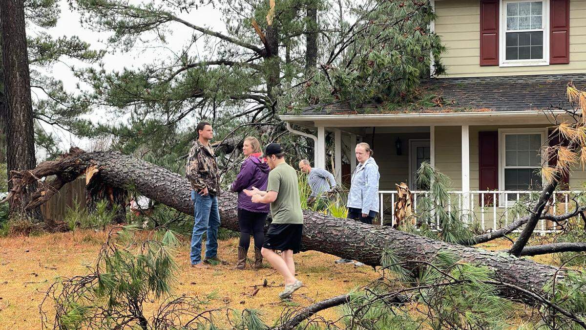 Warmer weather in early and late winter is creating conditions that can lead to tornadoes like the one that happened Sunday in Garner. Here, people check out a tree downed in a yard on Buckhorn Road in Garner after the EF-1 torando moved through the area.