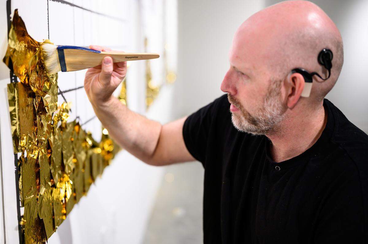 Designer Justin LeBlanc works on his new exhibition at CAM Raleigh, “Probable Normal Hearing.” He has woven a play on the old adage “silence is golden” through the exhibition’s narrative. Every piece glitters with 24-karat gold leaf. He designed it to inspire dialogue with visitors.