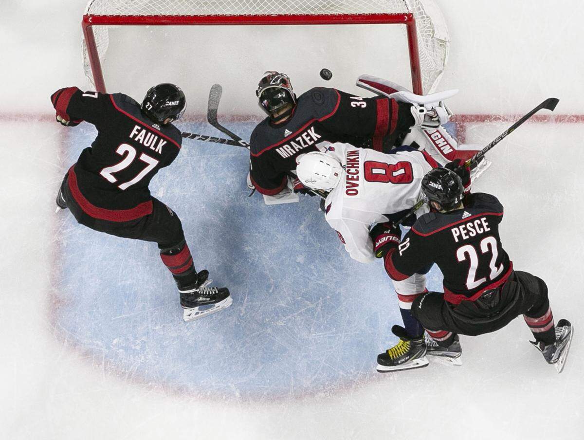 Washington Capitals’ Alex Ovechkin (8) pushes Carolina Hurricanes goalie Petr Mrazek (34) and the puck into the net during the third period in Game 6 of their first round Stanley Cup series on Monday, April 22, 2019 at PNC Arena in Raleigh, N.C. The goal was reviewed and disallowed.