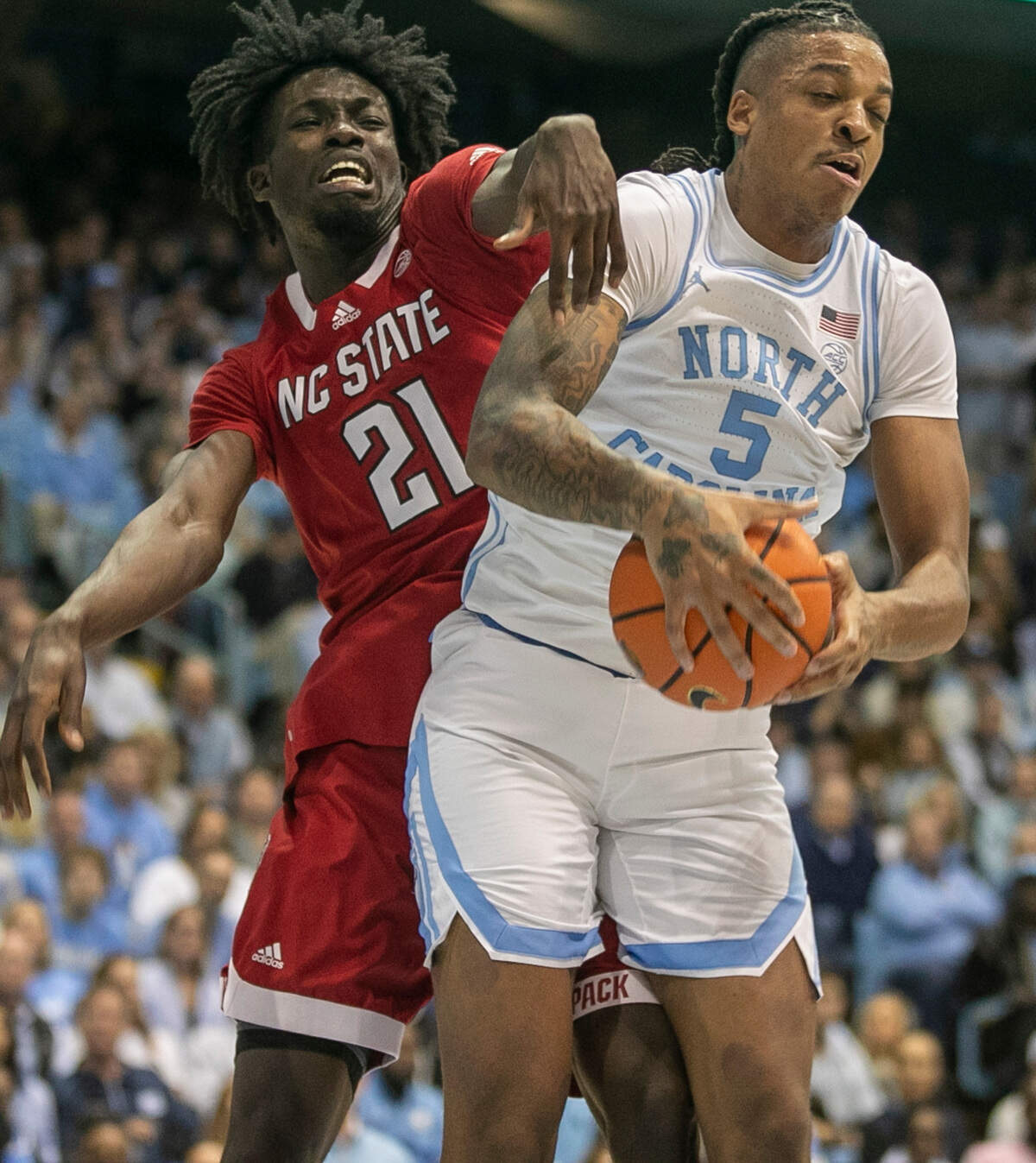 North Carolina’s Armando Bacot (5) secures a defensive rebound in the first against N.C. State’s Ebenezer Dowuona (21) on Saturday, January 21, 2023 at the Smith Center in Chapel Hill, N.C. Bacot scored 23 points and secured 18 rebounds.