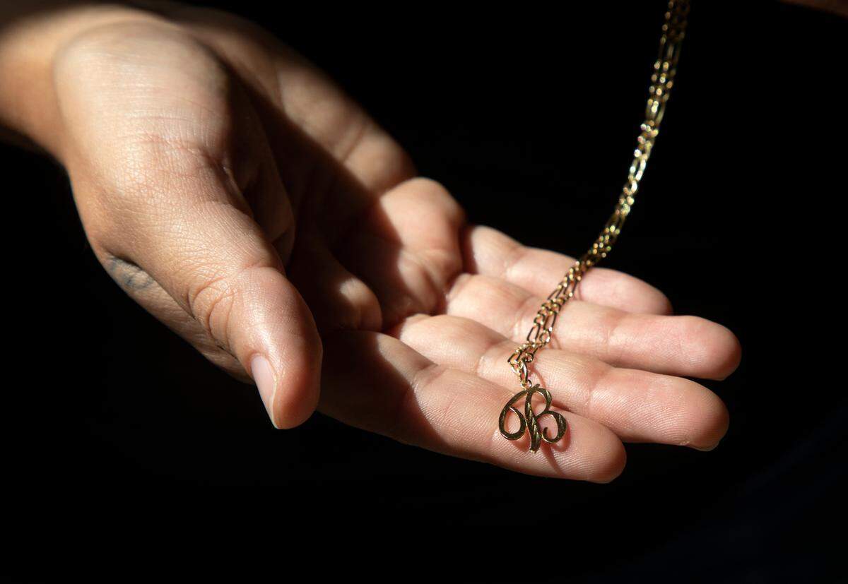 Bertha Mena, photographed on Monday, July 18, 2022, in Durham, N.C., holds a necklace she received as a teenager that she once pawned to support herself financially.