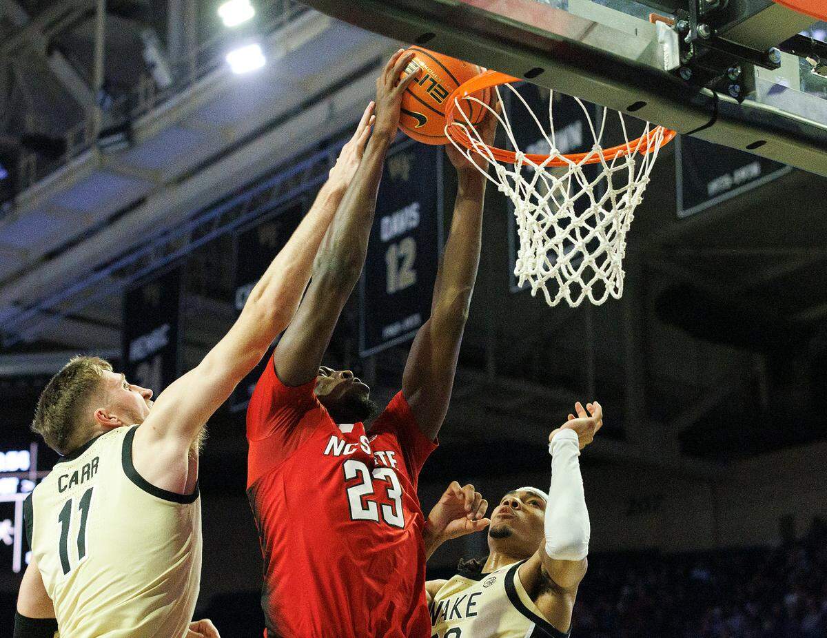 N.C. State’s Mohamed Diarra dunks over Wake Forest’s Andrew Carr and Hunter Sallis during the first half of the Wolfpack’s game on Saturday, Feb. 10, 2024, at Lawrence Joel Veterans Memorial Coliseum in Winston-Salem, N.C.