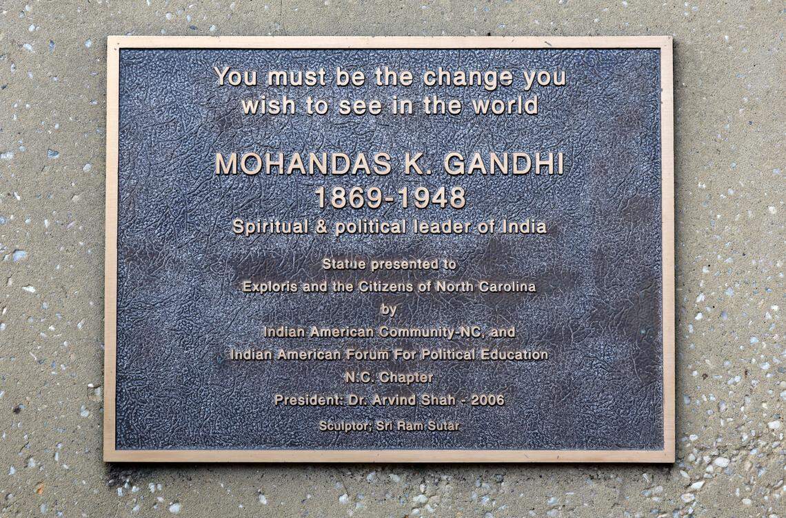 The plaque on the base of the statue of Mohandas Gandhi which stands outside the Marbles Kids Museum and IMAX theater. Photographed Wednesday, August 14, 2024.