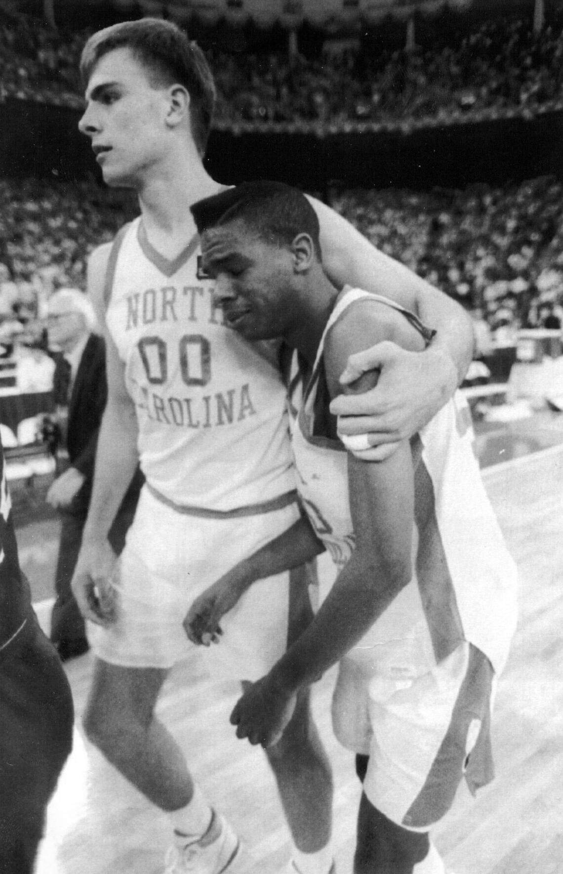 UNC’s Hubert Davis, right, is consoled by teammate Eric Montross after the Tar Heels were defeated by the Kansas Jayhawks in the semifinals of the NCAA tournament at the Hoosier Dome March 30, 1991.