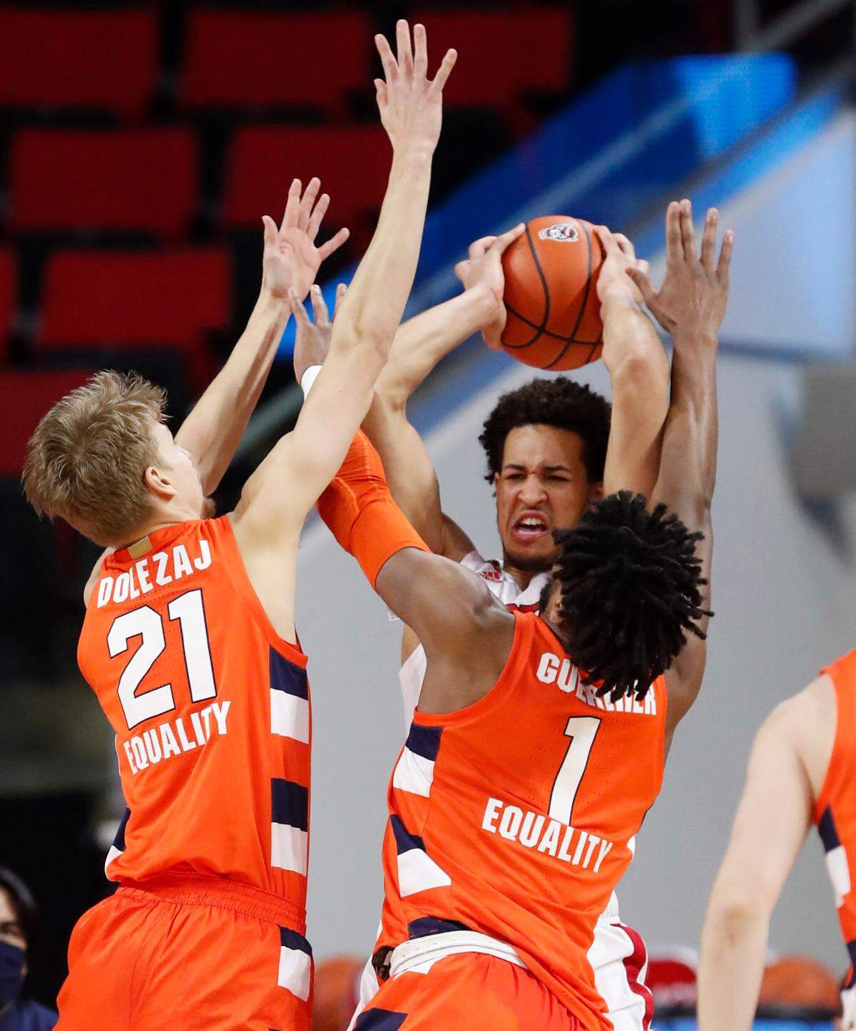 N.C. State’s Jericole Hellems (4) is pressured by Syracuse’s Marek Dolezaj (21) and Quincy Guerrier (1) and during the first half of N.C. State’s game against Syracuse at PNC Arena in Raleigh, N.C., Tuesday, February 9, 2021.