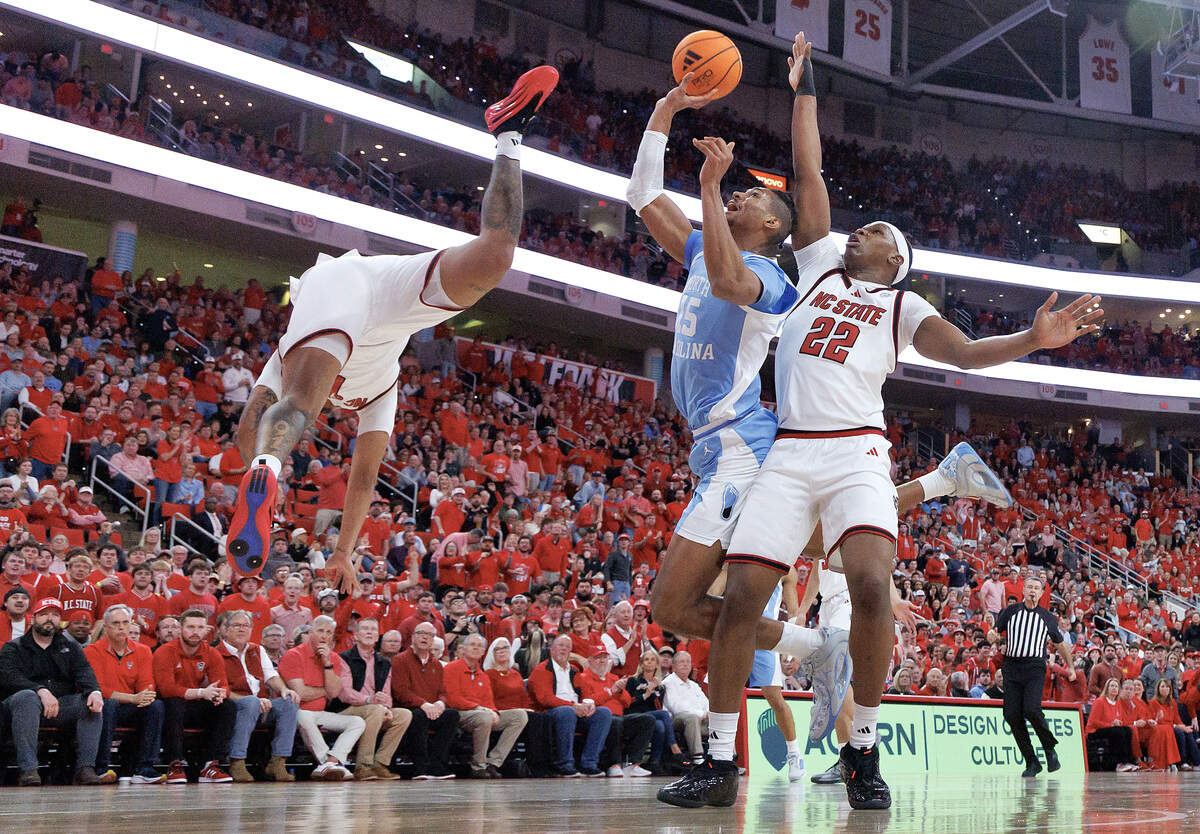 North Carolina's Jarin Stevenson drives to the basket against N.C. State's Darrion Williams and Ven-Allen Lubin in first half action. Williams left the game with an injury to the face after hitting the floor hard, but returned to action before the half.