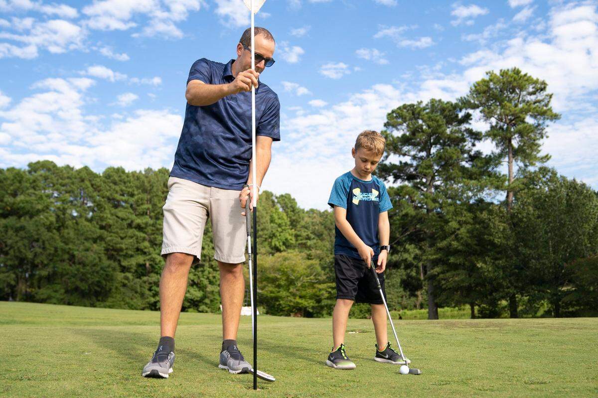 Ethan (8) and Dan Leeman practice golf together at 401 Par Golf in Raleigh, N.C. on Thursday, Aug. 18, 2022. Developers are planning to buy the 72 acres that 401 Par Golf sits on and build a master-planned residential and commercial community