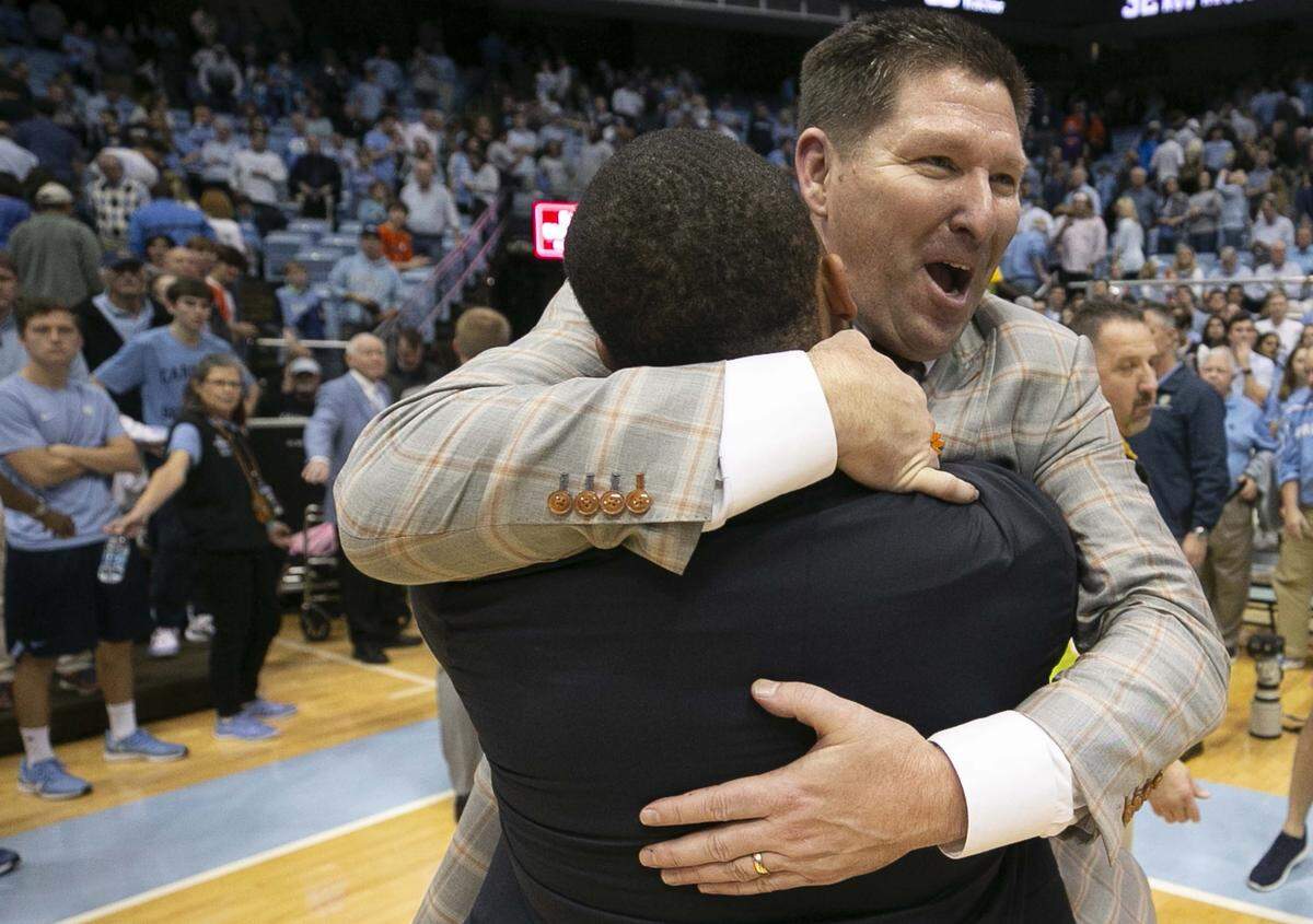 Clemson coach Brad Brownell embraces assistant coach Anthony Goins as they celebrate the Tigers’ 79-76 overtime victory over North Carolina on Saturday, January 11, 2020 at the Smith Center in Chapel Hill, N.C.