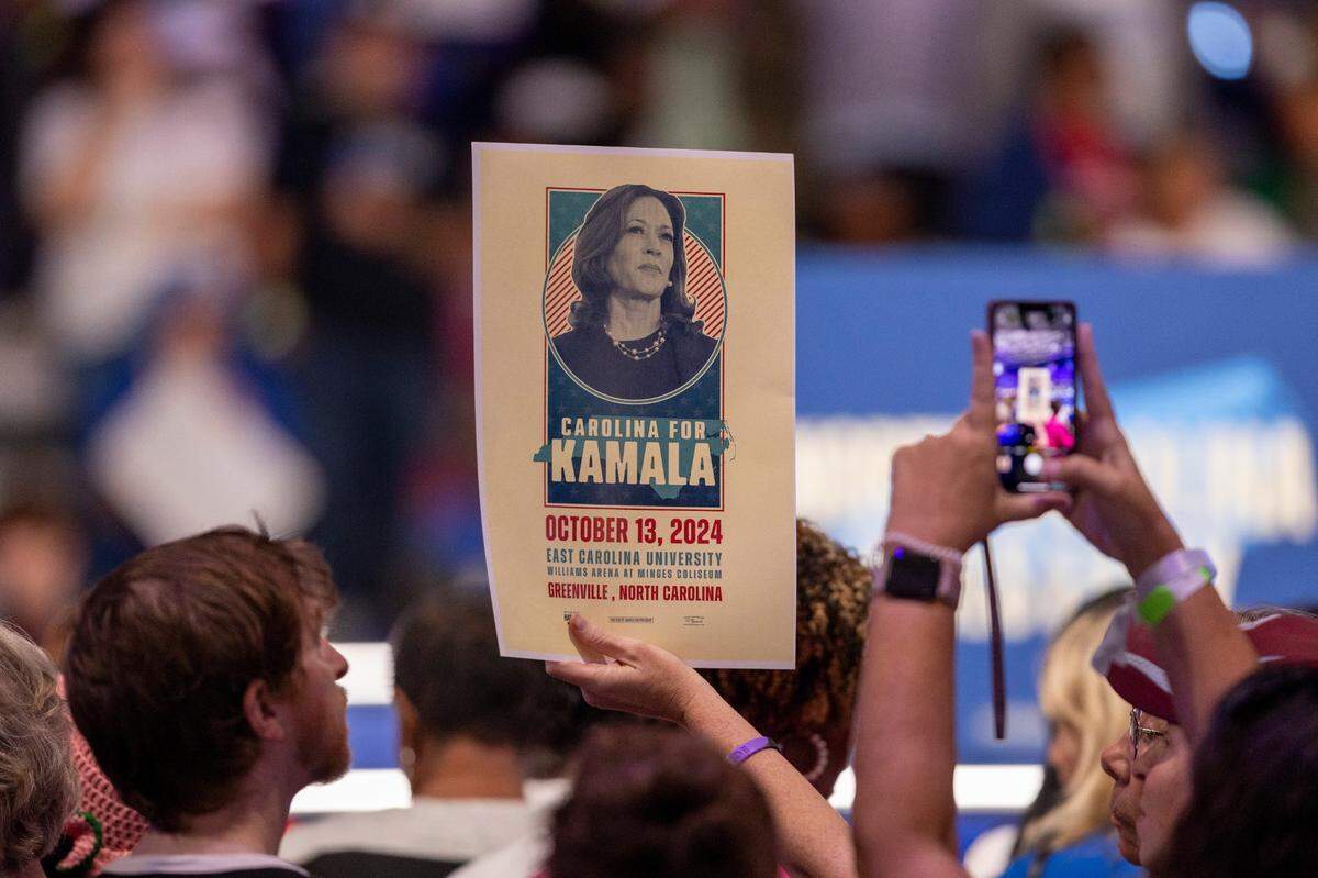 Supporters of Vice President Kamala Harris, the Democratic Presidential nominee, hold posters of her prior to her arrival at a rally on Sunday, October 13, 2024 at Minges Coliseum in Greenville, N.C.