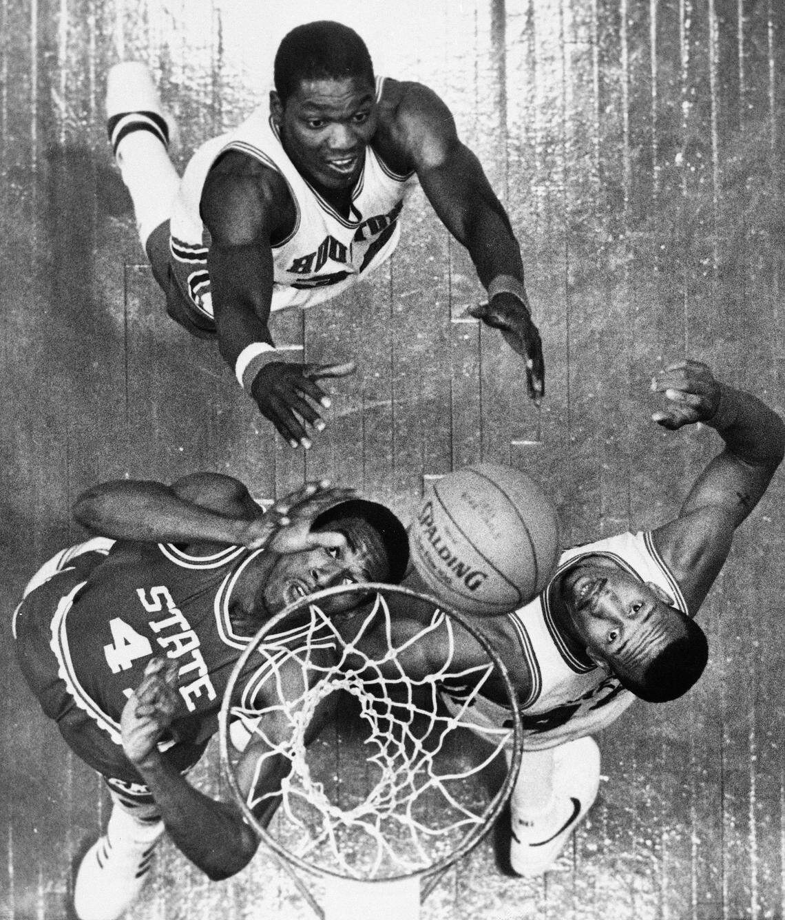 North Carolina State's Thurl Bailey (41), Houston's Akeem Abdul Olajuwon, rear, and Houston's Larry Micheaux, right, go for the rebound during NCAA game Monday night, April 4, 1983 in Albuquerque, N.M.