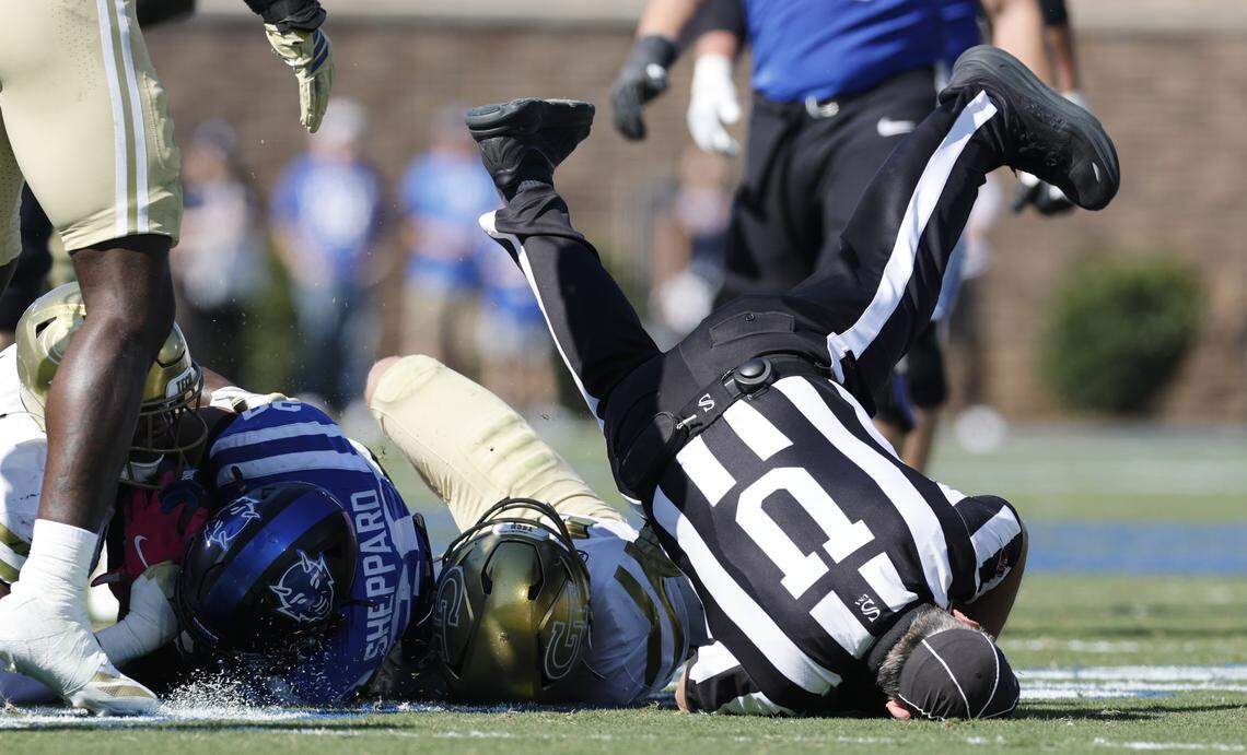 Umpire Danny Worrell goes into the turf as Duke’s Nate Sheppard (20) is tackled during the first half of Duke’s game against Georgia Tech at Wallace Wade Stadium in Durham, N.C., Saturday, Oct. 18, 2025.