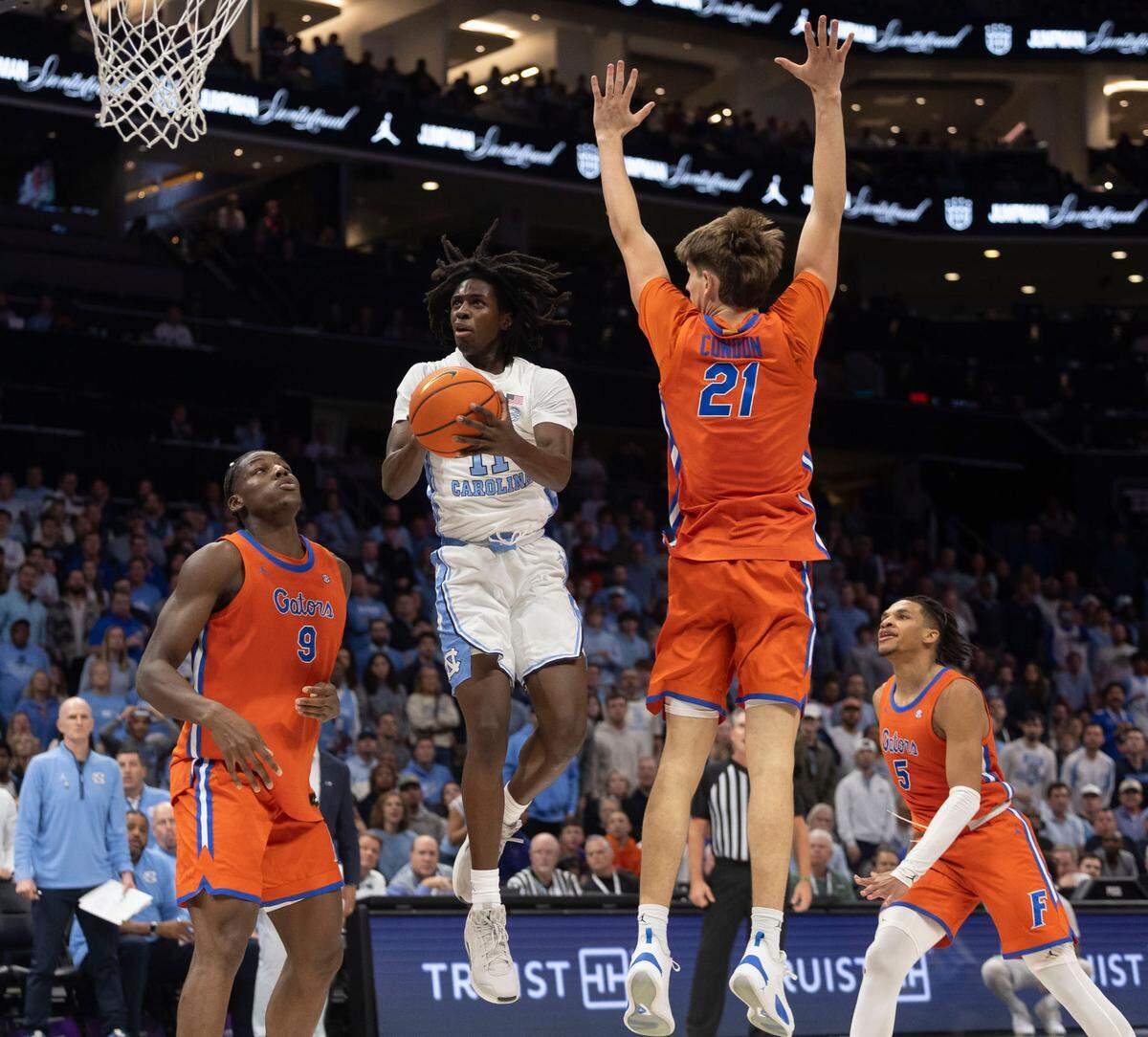 North Carolina guard Ian Jackson (11) breaks to the basket between Florida’s Reuben Chinyelu (9) and Alex Condon (21) for two of his 11 points in the second half during the Jumpman Invitational on Tuesday, December 17, 2024 at the Spectrum Center in Charlotte, N.C.
