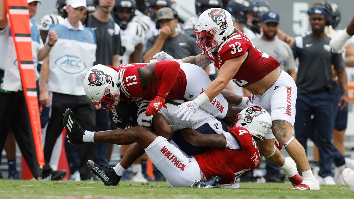 N.C. State’s Cyrus Fagan (4), Tyler Baker-Williams (13) and Drake Thomas (32) stop Charleston Southern wide receiver Vinson Davis (11) during the first half of N.C. State’s game against Charleston Southern at Carter-Finley Stadium in Raleigh, N.C., Saturday, Sept. 10, 2022.