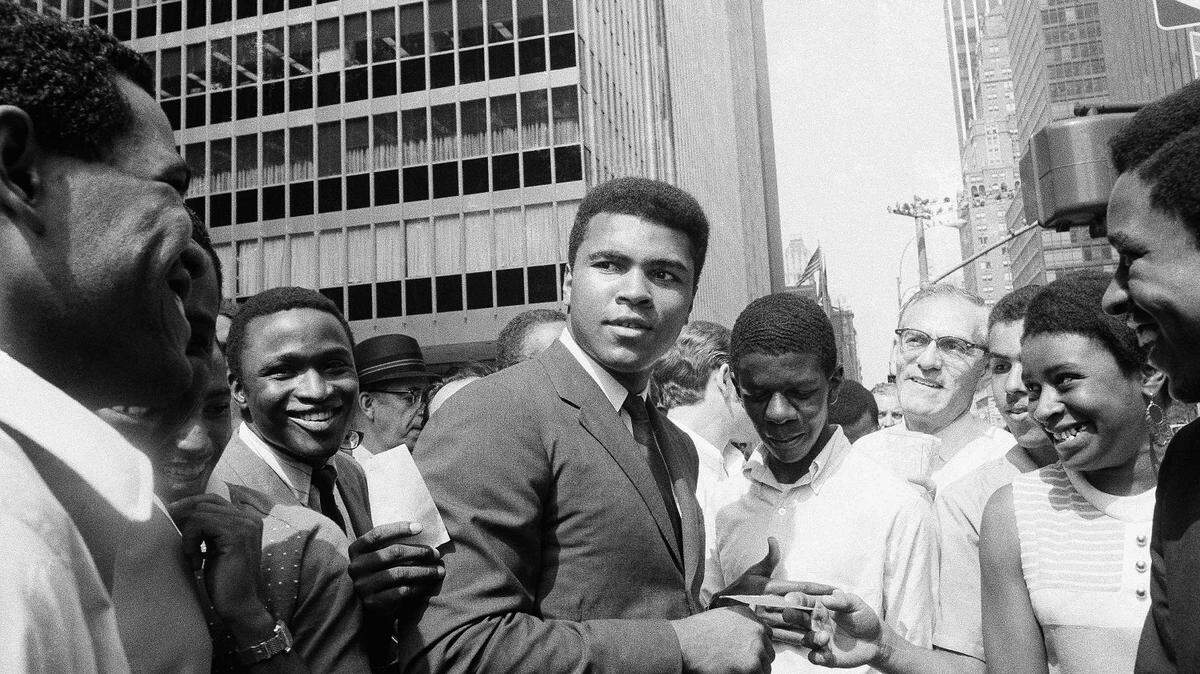 Former world heavyweight boxing champion, Muhammad Ali, the subject of a new PBS Ken Burns documentary, is surrounded by autograph seekers at 51st Street and Sixth Avenue in Manhattan borough of New York, Aug. 23, 1968. He was en route to a television studio when pedestrians mobbed him.