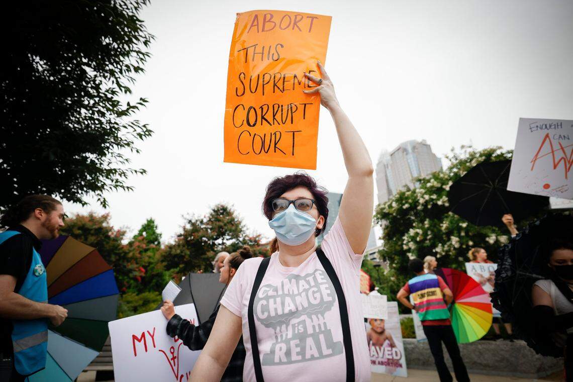 Abortion rights activist Jennifer Williams, of Charlotte, N.C., holds a sign along side other demonstrators during a rally at First Ward Park in Charlotte, Sunday, July 10, 2022.