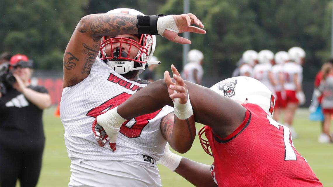 N.C. State defensive tackle Corey Durden (48), left, tries to get around N.C. State offensive tackle Ikem “Ickey” Ekwonu (79) during the Wolfpack’s first practice of fall camp in Raleigh, N.C., Wednesday, August 4, 2021.