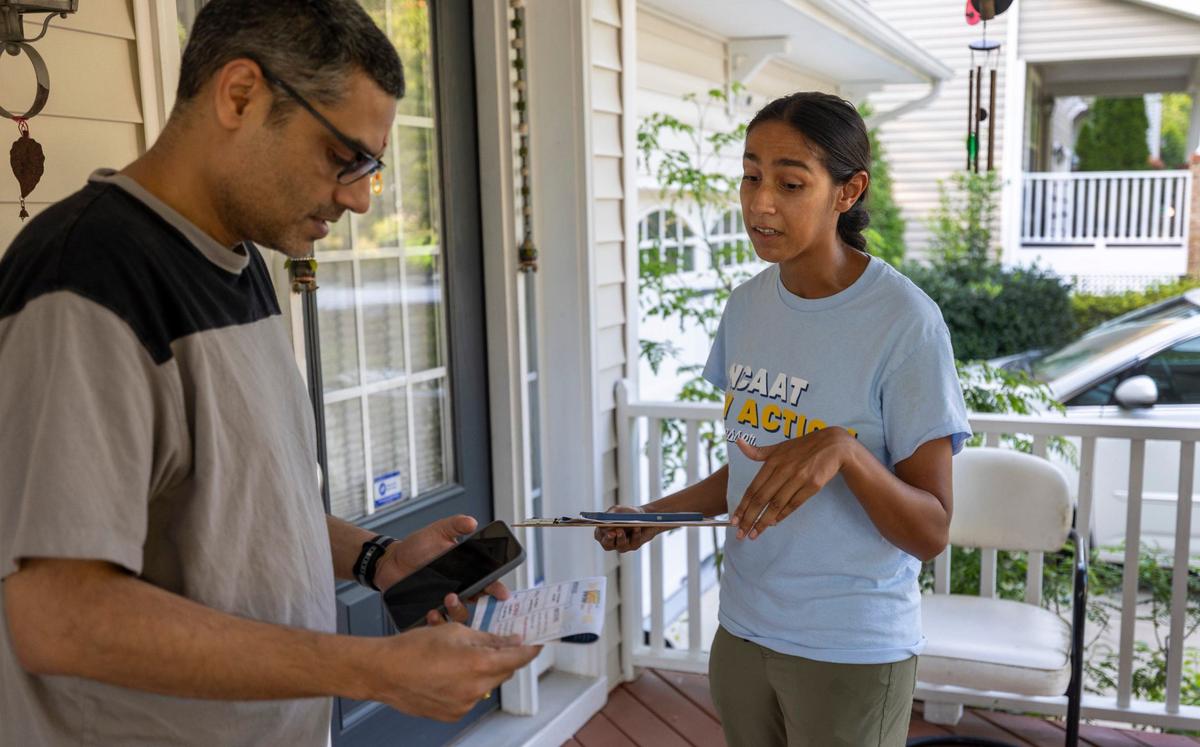 Annar Parikh, a canvasser for North Carolina Asian Americans Together, talks with Ravi Parmar, explaining his voting options and inquiring about his top voting issues on Wednesday, July 31, 2024 in Morrisville, N.C.