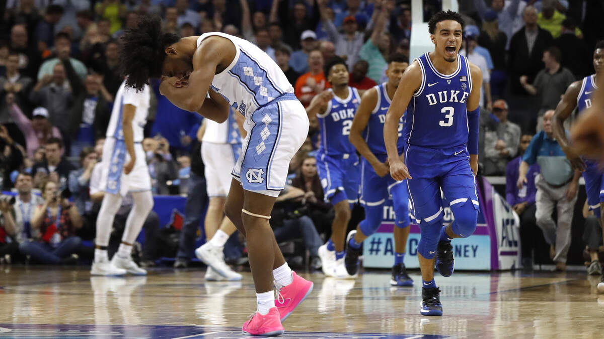 Duke’s Tre Jones (3) celebrates as North Carolina’s Coby White (2), left, is dejected after Duke’s 74-73 victory over UNC in the semifinals of the 2019 ACC Tournament in Charlotte, N.C., Friday, March 15, 2019.