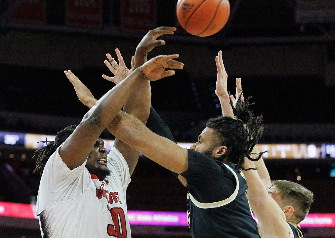 N.C. State’s DJ Burns Jr. looks to pass over Wake Forest’s Efton Reid III during the first half of the Wolfpack’s game at PNC Arena on Tuesday, Jan. 16, 2024, in Raleigh, N.C.