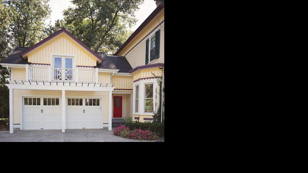 Carriage-house garage doors manufactured by Clopay are an extension of the house’s architecture. Black metal pulls are the finishing touch on these garage doors, which still work like conventional sectional overhead doors by rolling up and down.
