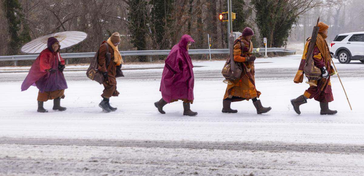 A procession of Buddhist monks walks along snow-covered Raleigh Boulevard in Raleigh on Sunday morning, Jan. 25, 2026. The monks are making a 2,300-mile pilgrimage from Texas to Washington, D.C., as part of the Walk for Peace, an effort to promote peace, compassion and national unity.