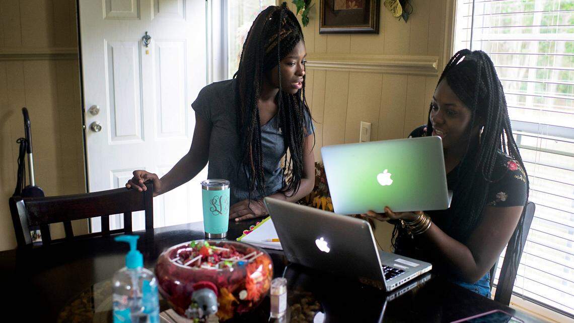 Shekinah Lennon, 17, and her sister, Orlandria, 14, try to connect to a science class from their home in Orrum, N.C., Oct. 29, 2020. Millions of American students are grappling with the challenge of learning remotely without adequate home internet service, particularly in poorer locales like Robeson County.