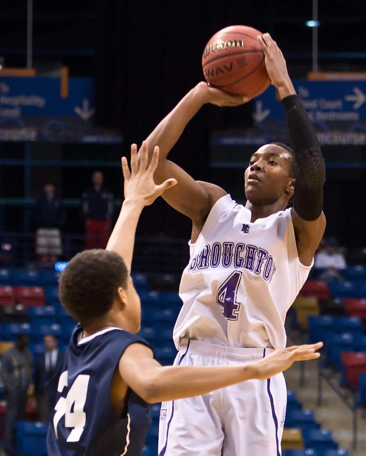Broughton senior Devonte' Graham (4) puts up a jump shot over Hillside sophomore Marcus Bowling (34) in 2013.