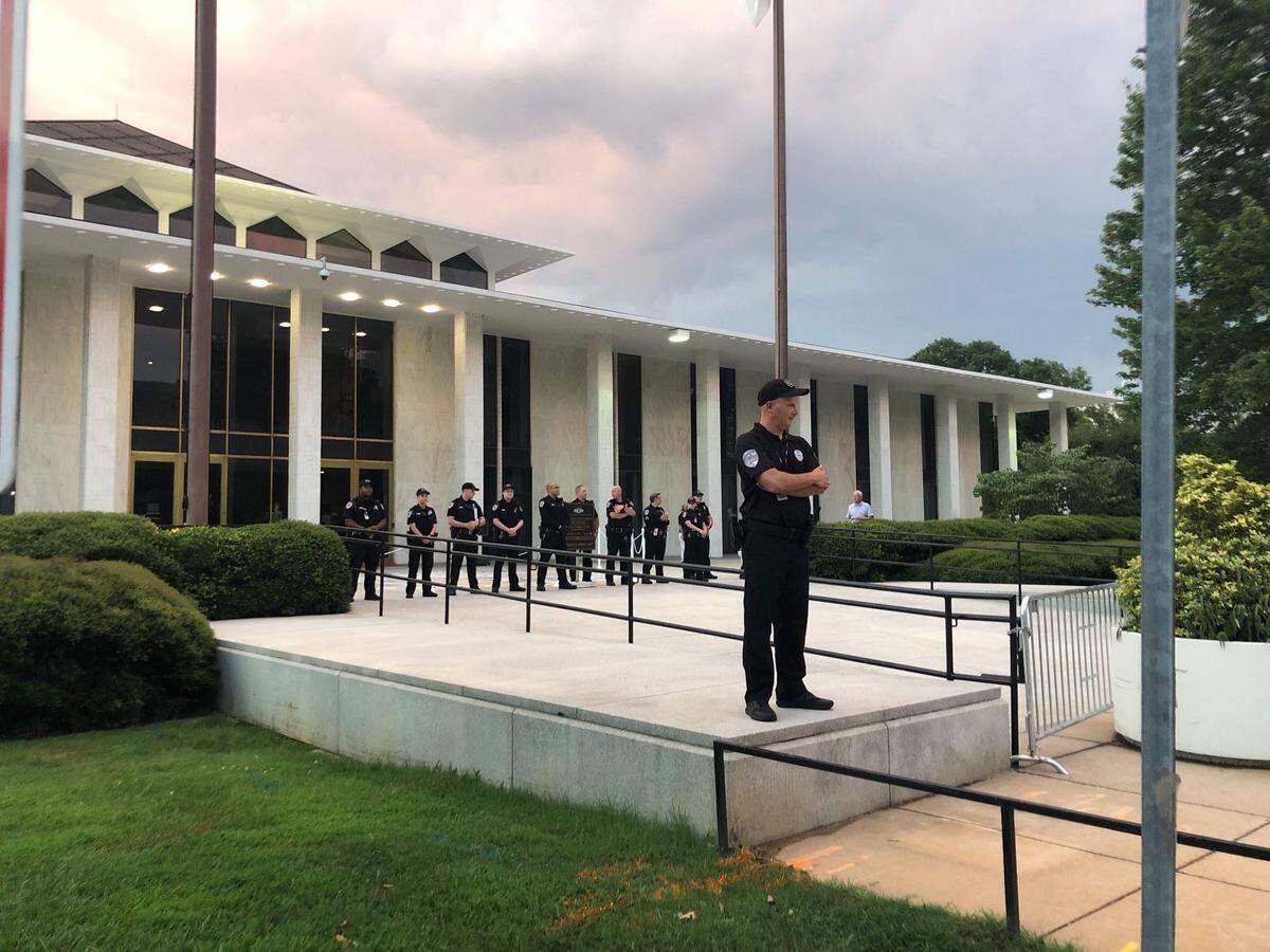 Law enforcement officers watch Saturday night as protesters march from the Executive Mansion toward Glenwood South in downtown Raleigh.