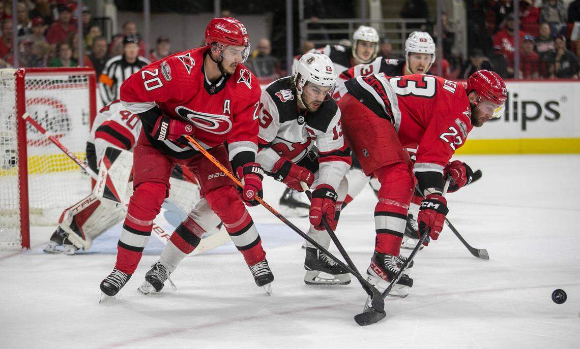The Carolina Hurricanes Sebastian Aho (20) and Stefan Noesen (23) put the squeeze on the New Jersey Devils Nico Hischier (13) as they battle for position in the first period during Game 5 of their second round Stanley Cup playoff series on Thursday, May 11, 2023 at PNC Arena in Raleigh, N.C.
