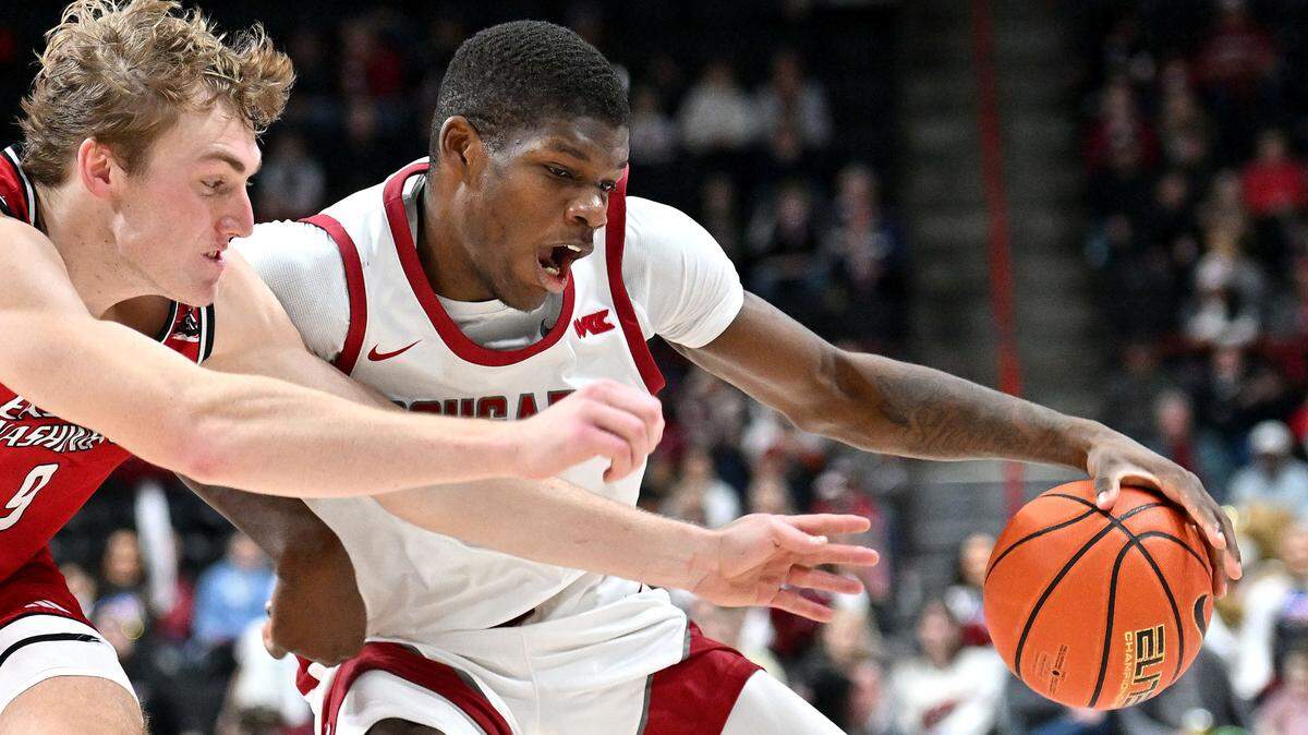 Washington State Cougars guard Cedric Coward (0) controls the ball against Eastern Washington Eagles guard Andrew Cook (9) in the first half at Spokane Veterans Memorial Arena.