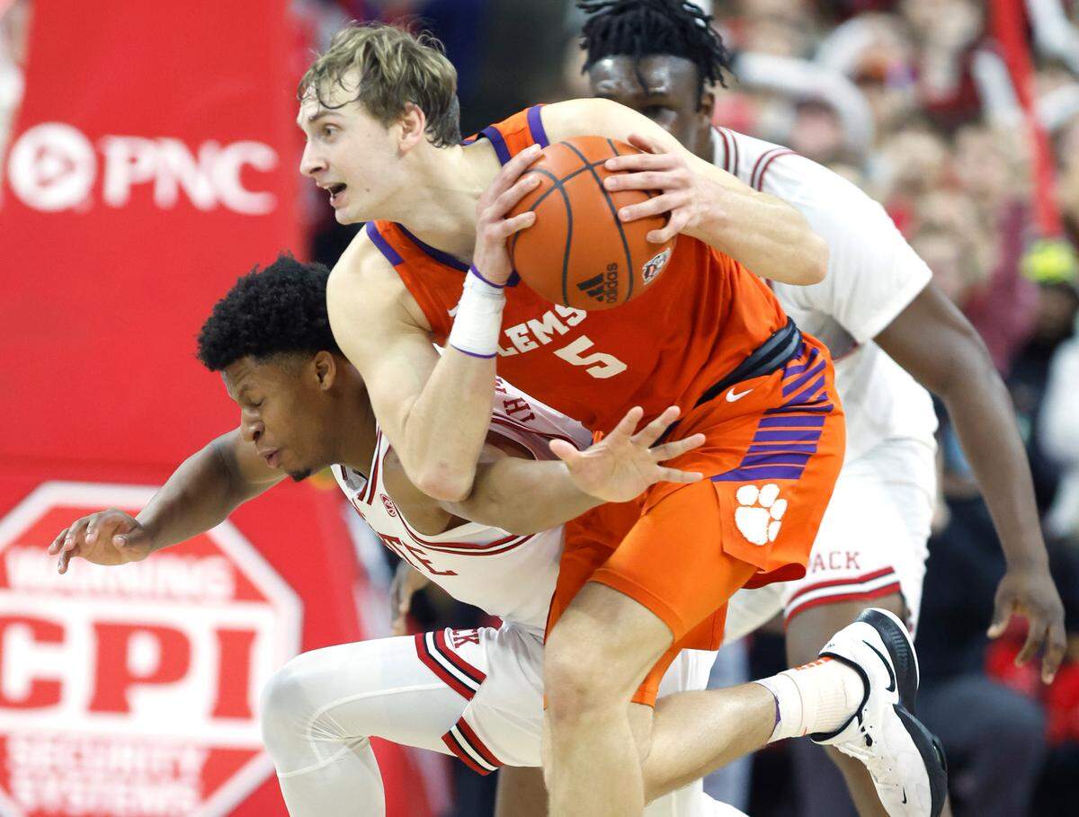N.C. State’s LJ Thomas (4) tries to steal the ball from Clemson’s Hunter Tyson (5) during the first half of N.C. State’s game against Clemson at PNC Arena in Raleigh, N.C., Saturday, Feb. 25, 2023.