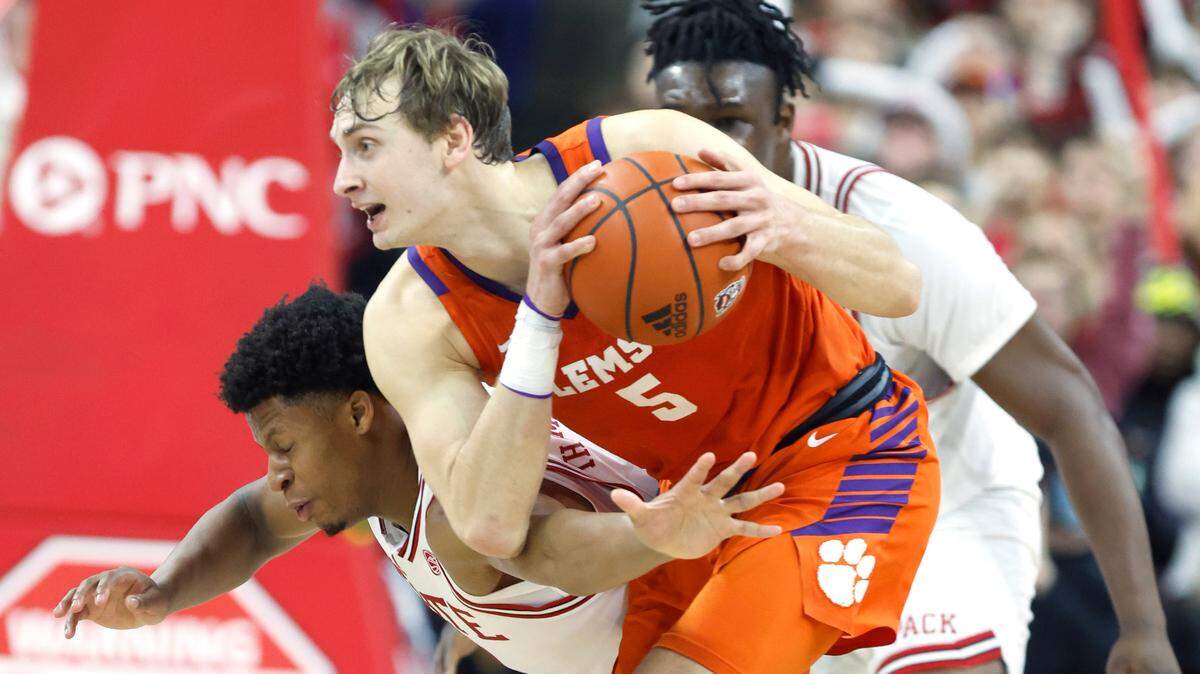 N.C. State’s LJ Thomas (4) tries to steal the ball from Clemson’s Hunter Tyson (5) during the first half of N.C. State’s game against Clemson at PNC Arena in Raleigh, N.C., Saturday, Feb. 25, 2023.