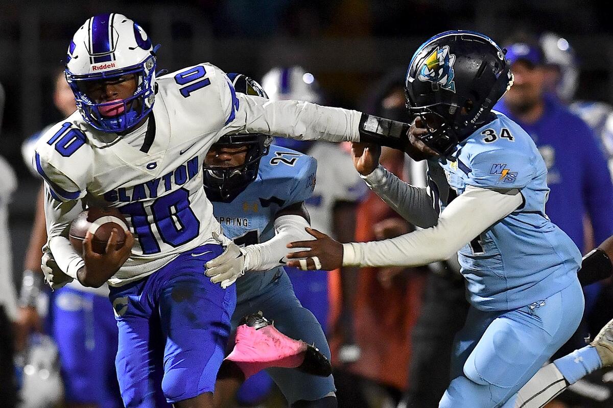 Clayton quarterback Johnathan Montague (10) stiff-arms Willow Spring’s Josiah Gray (34) and runs for the touchdown during the first half. The Clayton Comets and the Willow Spring Storm met in a conference football game in Fuquay-Varina, N.C. on October 20, 2023.