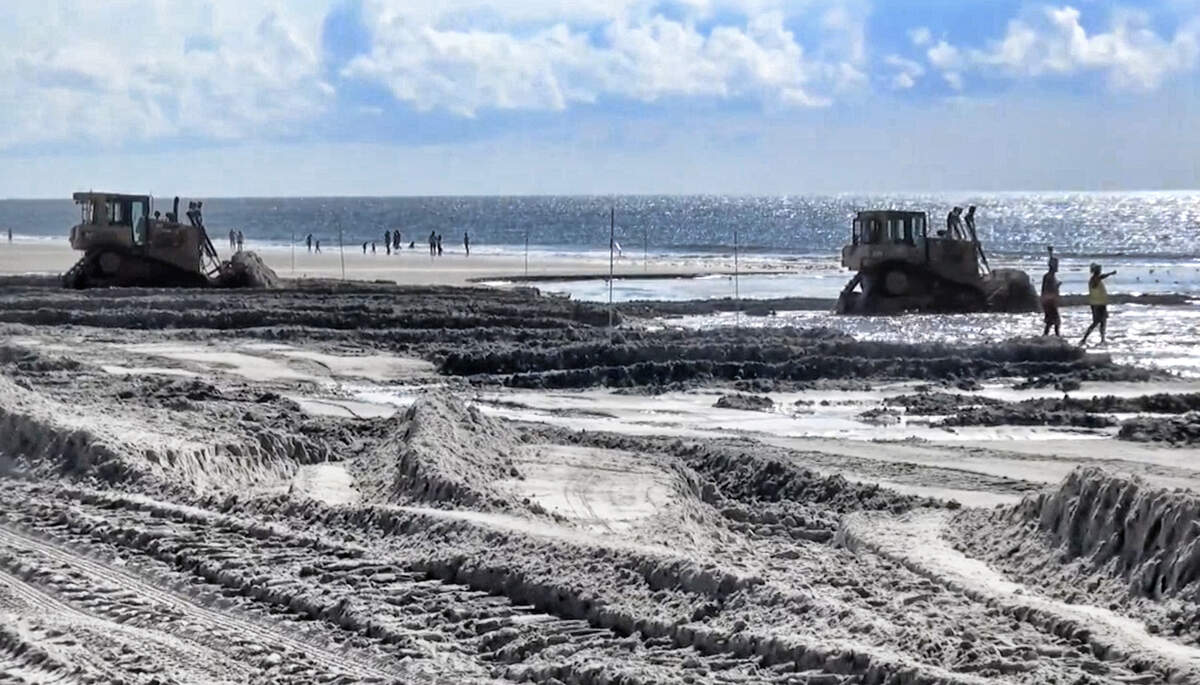 In this file photo, bulldozers move sand as part of a beach nourishment project in Southern Shores, N.C.