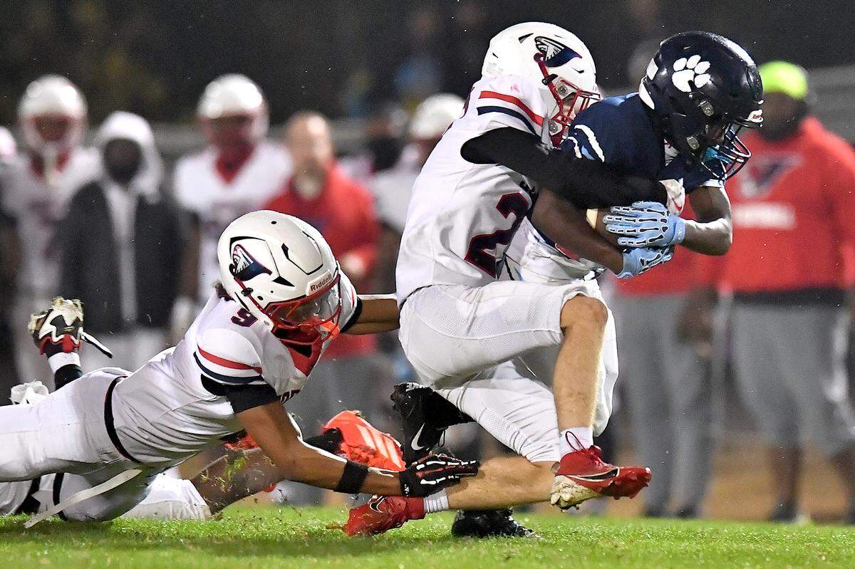 Millbrook running back Santonis Wright (23) runs for the first down against Jordan's Aiden Pazdzior (27) during the first half. The Millbrook Wildcats and the Jordan Falcons met in the third round of the NCHSAA 8A football playoffs in Raleigh, N.C. on November 21, 2025. 