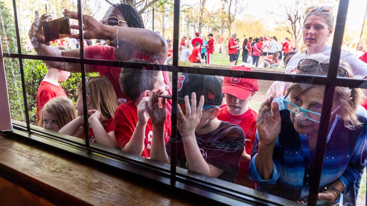 Fans clamor to get a view inside the Triangle Town Center Applebee’s as NC State’s DJ Horne and DJ Burns Jr. sign hundreds of autographs on Tuesday, April 2, 2024 ahead of the Wolfpack’s Final Four game on Saturday.