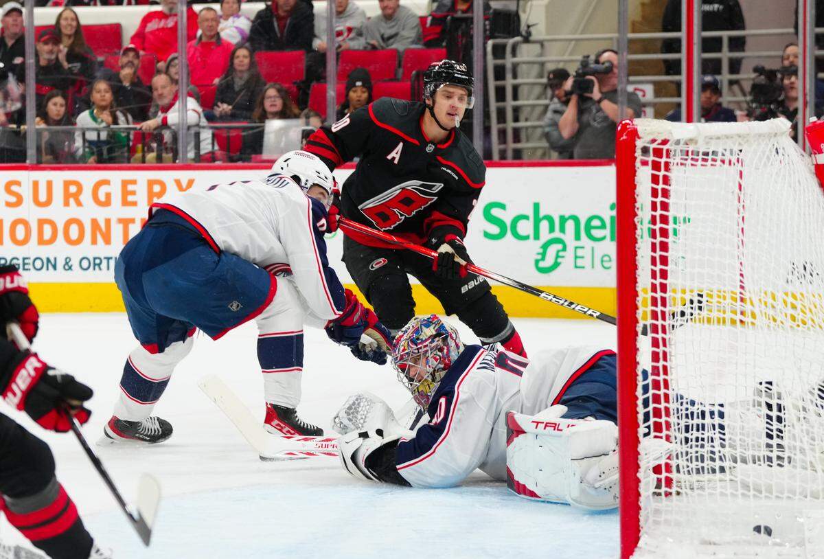 Carolina Hurricanes center Sebastian Aho (20) scores against Columbus Blue Jackets goaltender Elvis Merzlikins (90) during the first period at Lenovo Center.