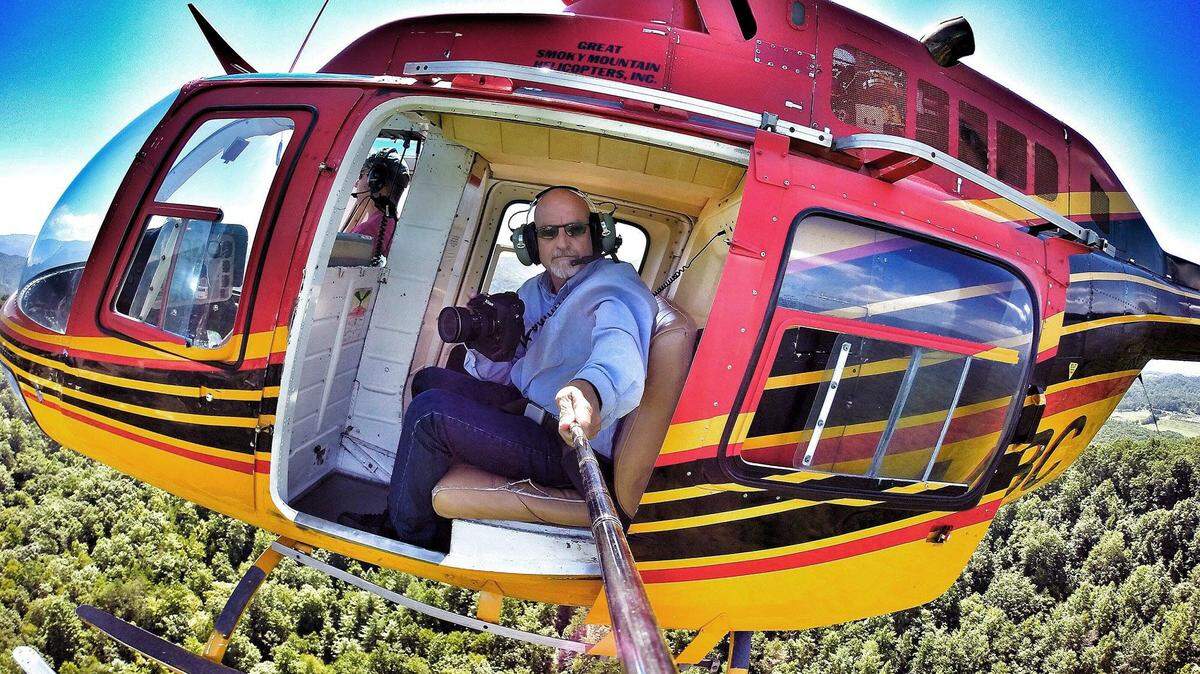 News & Observer photojournalist Chuck Liddy uses a camera on a pole to photograph himself working from the ABC11 helicopter.