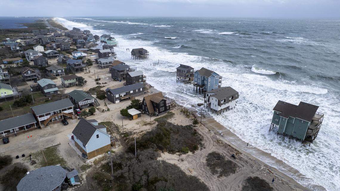 Rough surf threatens beach homes during high tide in Buxton Friday. Nine homes in the community have collapsed into the Atlantic Ocean since mid-September.