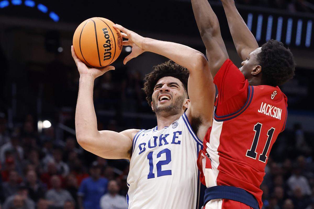 Duke’s Cameron Boozer (12) drives to the basket as St. John's Ian Jackson (11) defends during the second half of Duke’s 80-75 victory over St. John’s in the Sweet 16 of the NCAA Men’s Basketball East Regional at Capital One Arena in Washington, D.C., Friday, March 27, 2026.