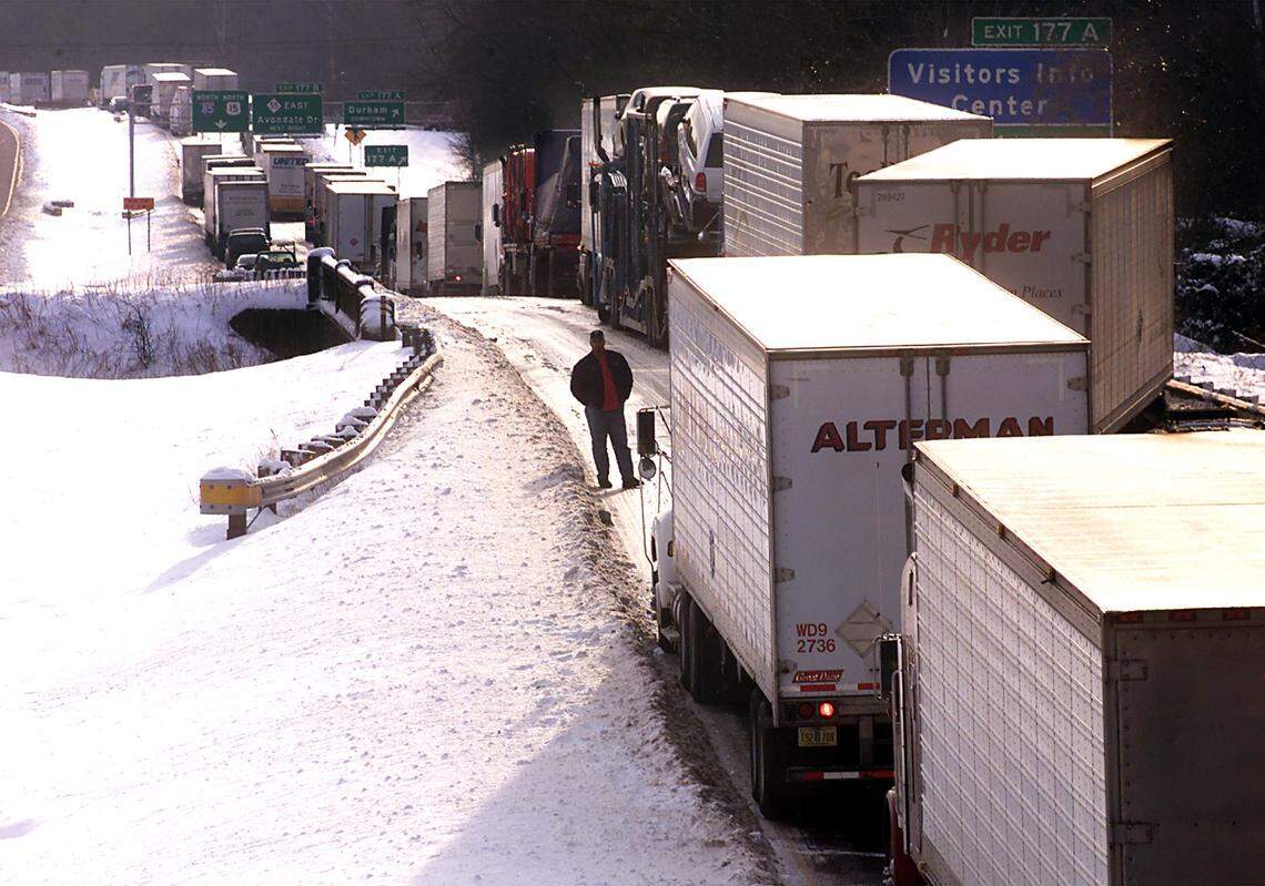 A truck driver stands in front of his gig and looks back at the traffic snarled along I-85 north in Durham in 2000.