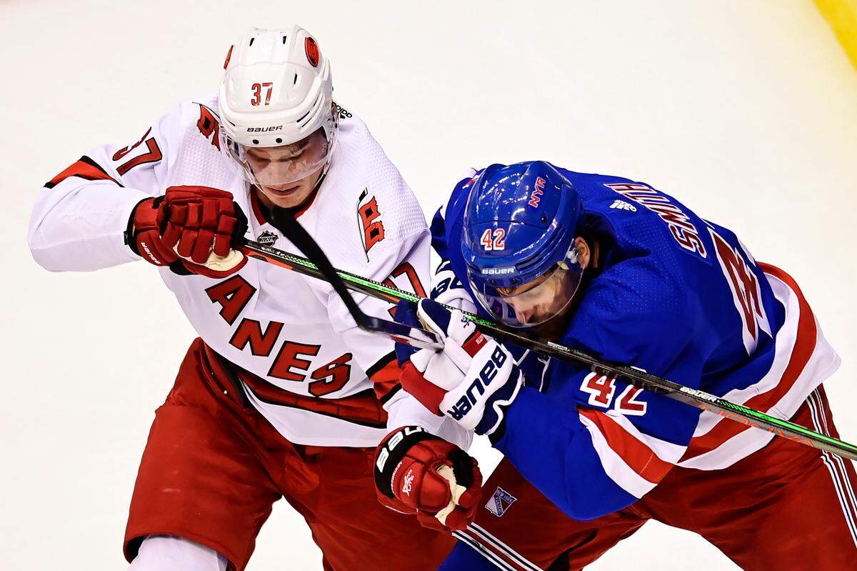 Carolina Hurricanes’ Andrei Svechnikov (37) battles with New York Rangers’ Brendan Smith (42) during first period NHL Eastern Conference Stanley Cup playoff action in Toronto on Tuesday, Aug. 4, 2020. (Frank Gunn/The Canadian Press via AP)
