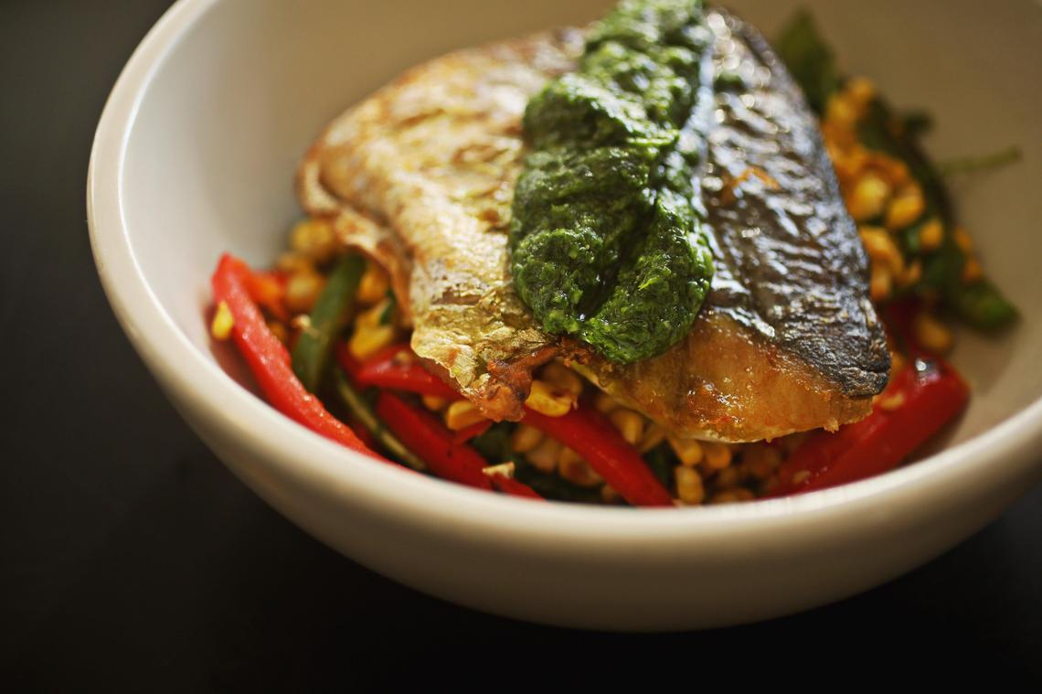 Pan-seared N.C. sea trout, beached on a colorful dune of greens, corn and red bell peppers, is a keeper on the menu at Crook’s Corner in Chapel Hill, NC.