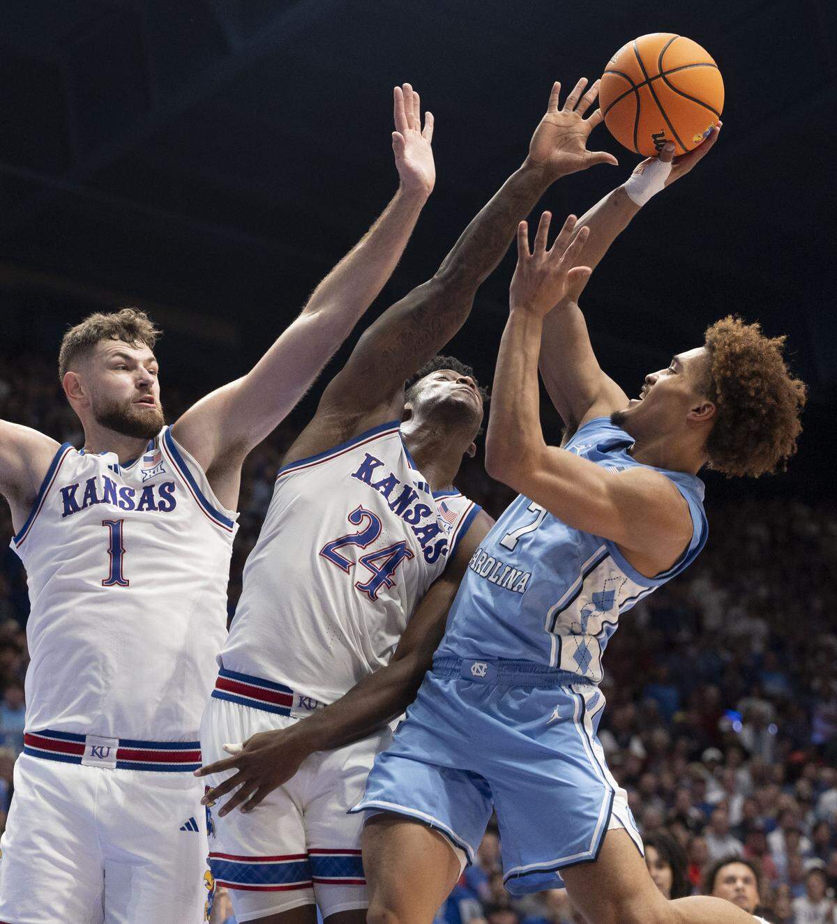 North Carolina guard Seth Trimble (7) puts up a shot against Kansas center Hunter Dickinson (1) and forward K.J. Adams Jr. (24) in the second half on Friday, November 8, 2024 at Allen Fieldhouse in Lawrence, Kansas.  Trimble lead North Carolina with 19 points. 