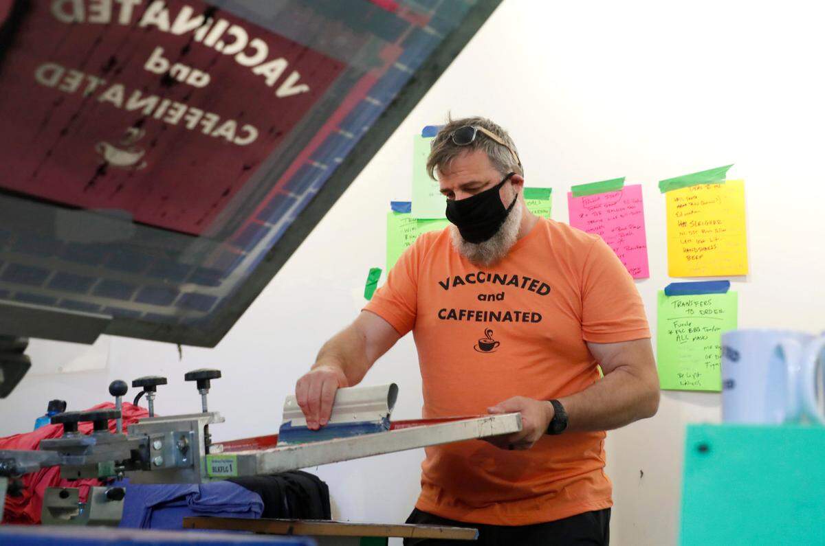 John Pugh, owner of the House of Swank Clothing store in downtown Raleigh, N.C., gets ready to print on a t-shirt at the store Wednesday, May 19, 2021.