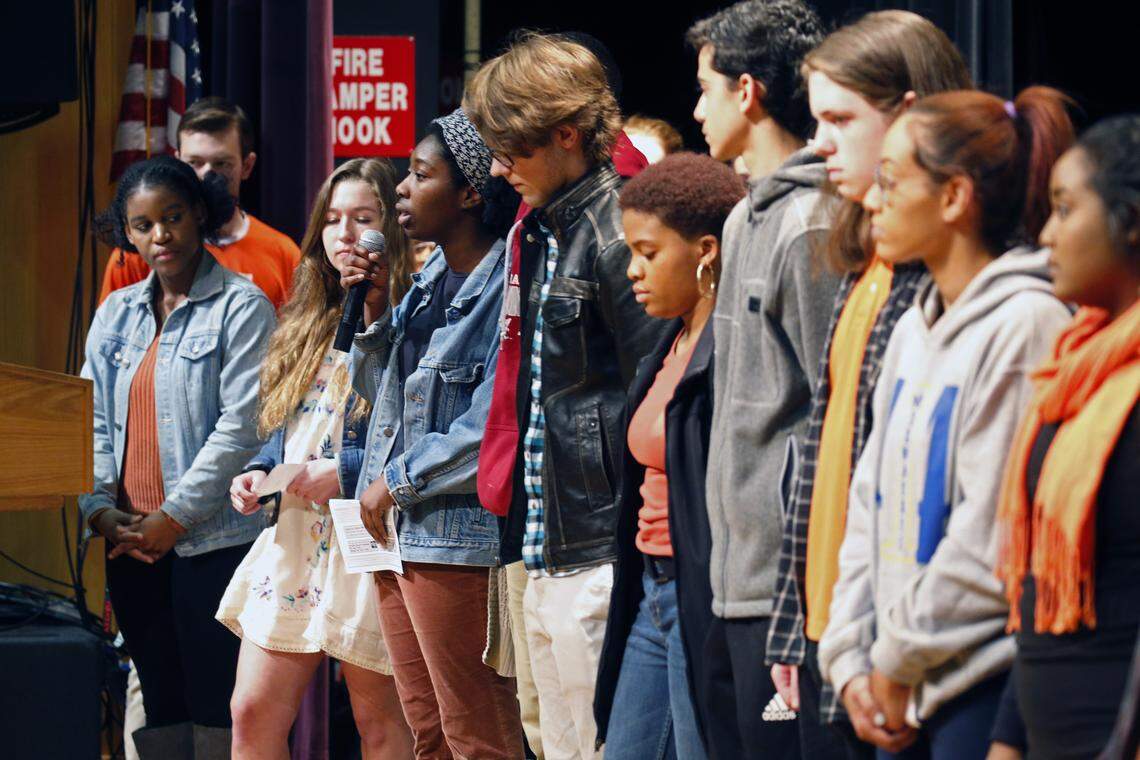 Students read off the names of the people killed in the shooting at a high school in Parkland Florida last month as hundreds of students crowd the Broughton High School auditorium for a rally opposing school shootings on March 21, 2018.  Several hundred more were in an overflow gym, bringing estimates to over 1000 students participating.