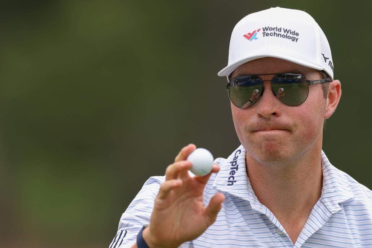 Ben Griffin waves to the crowd after his final putt on the 18th green during the final round of the Wyndham Championship golf tournament. 