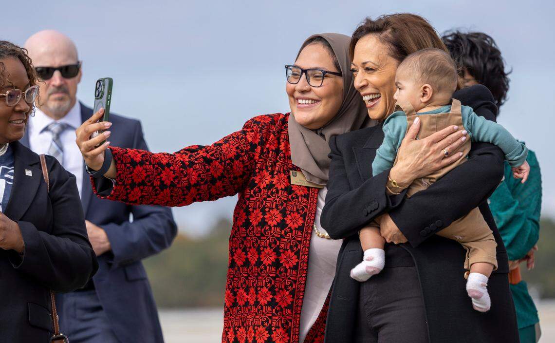 Vice President Kamala Harris stops for a photo with Durham County Commissioner Nida Allam and her child on the tarmac at Raleigh-Durham International Airport prior to a campaign stop at Coastal Credit Union Music Park at Walnut Creek in Raleigh on Wednesday, October 30, 2024.