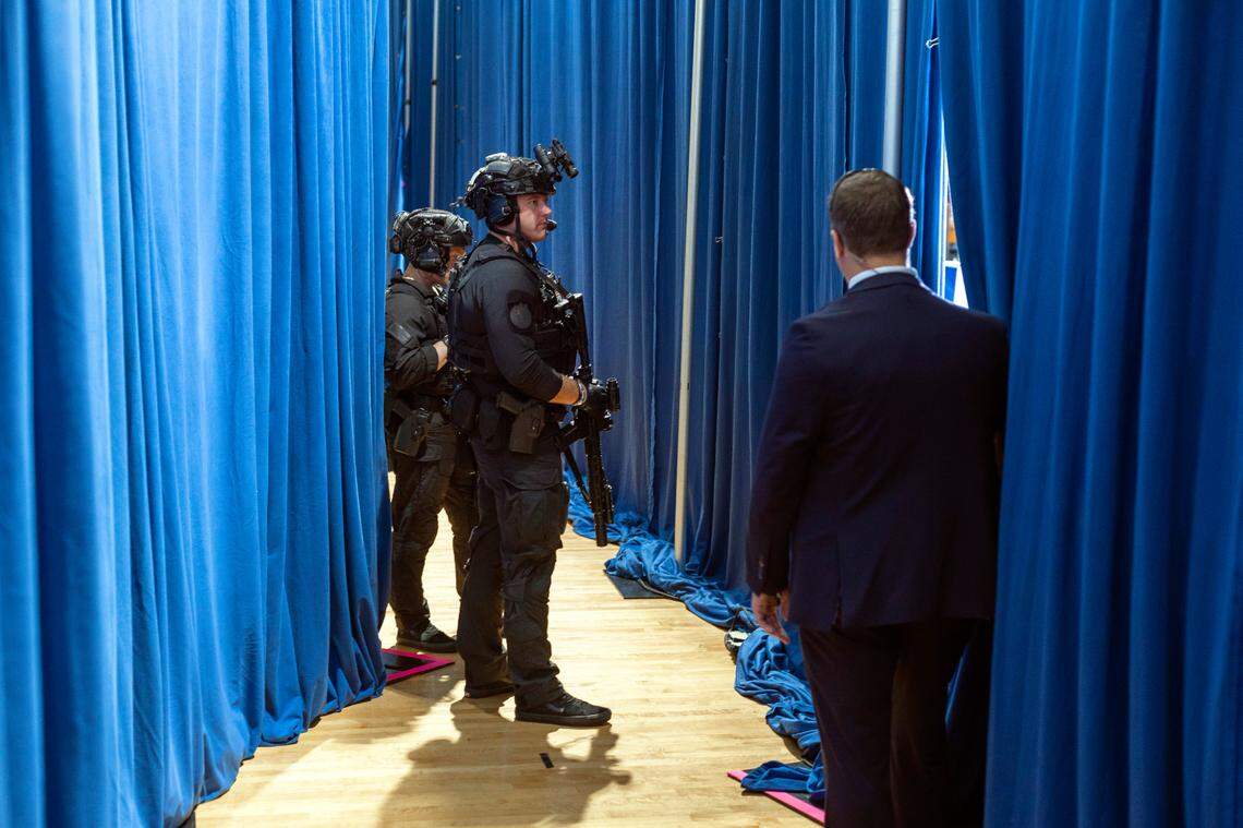 Security detail armed with long guns, stand backstage behind Vice President Kamala Harris as she delivers remarks during a campaign rally at Westover High School on Thursday, July 18, 2024 in Fayetteville, N.C.